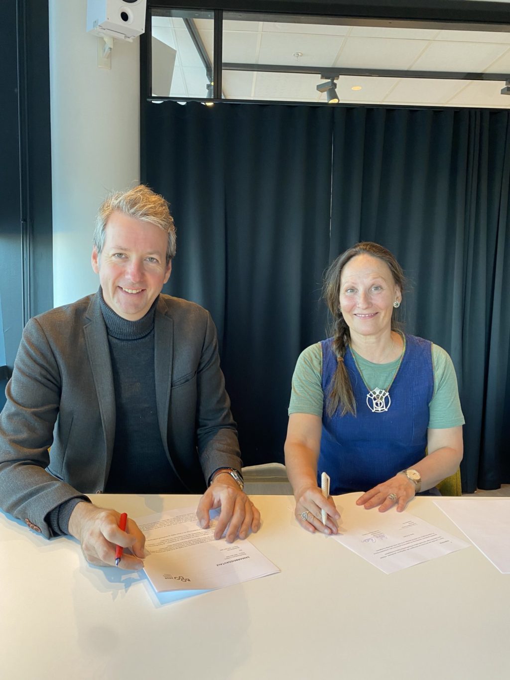 André Wallan Larsen/direktør for Bodø2024 og teatersjef Cecilia Persson/Åarjelhsaemien Teatere, signerer avtalen.