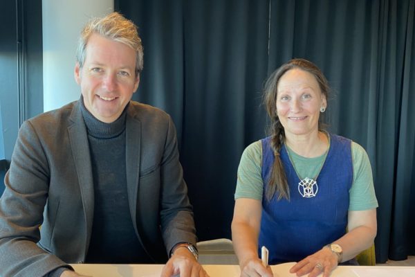 André Wallan Larsen/direktør for Bodø2024 og teatersjef Cecilia Persson/Åarjelhsaemien Teatere, signerer avtalen.